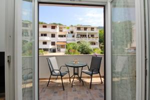 a patio with a table and chairs on a balcony at Apartment Sersic in Baška