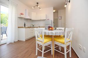 a kitchen and dining room with a table and chairs at Apartment Sersic in Baška