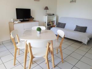 uma sala de estar com uma mesa e cadeiras e um sofá em Le Garden 250 m plage du Chay em Royan