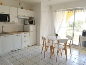 a kitchen with a table and chairs and a table and a window at Le Garden 250 m plage du Chay in Royan
