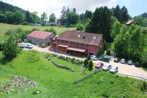 eine Luftansicht eines Hauses mit Autos auf einem Feld in der Unterkunft Gîtes du Kreuzweg in Le Hohwald