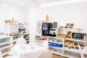 a room with white tables and white chairs and a kitchen at DC Mesones 21 in Lerma