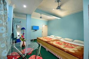 two beds in a room with blue walls at Hotel Airways in Kolkata