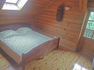 um quarto com uma cama num quarto de madeira em Pas Medžiotoją Motelis em Kryžkalnis