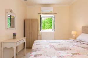 a bedroom with a bed and a desk and a window at MarGreCo in Garitsa in Corfu