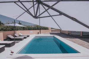 an indoor swimming pool with a glass roof at Poolside Hideout Apartments in Novalja