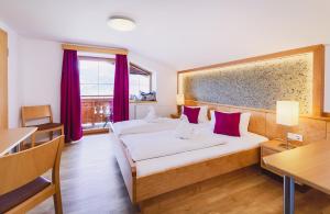 Łóżko lub łóżka w pokoju w obiekcie Panorama Hotel Guggenbichl - inkl Sommerkarte, einmaliger Eintritt ins Tauern Spa & bester Ausblick über Kaprun