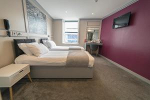 
a bedroom with a bed and a desk at Central Station Hotel Liverpool in Liverpool
