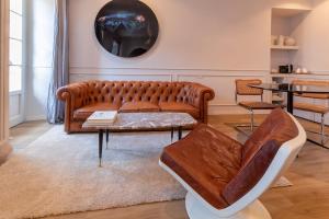 a living room with a brown couch and a table at Suites Menaggio in Menaggio