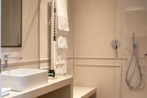 a white bathroom with a sink and a shower at Suites Menaggio in Menaggio