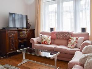 a living room with a couch and a tv at Brims cottage in Aberfeldy