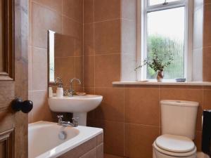 a bathroom with a sink and a toilet and a window at Brims cottage in Aberfeldy +11 photos
