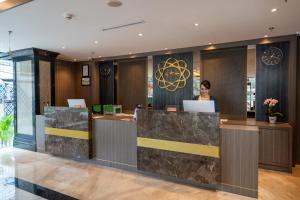 a woman standing at a counter in a hotel lobby at Arthama Tanah Abang Jakarta in Jakarta