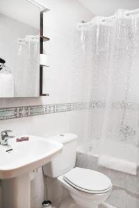 a white bathroom with a toilet and a sink at Piso turístico Belisa in Lerma