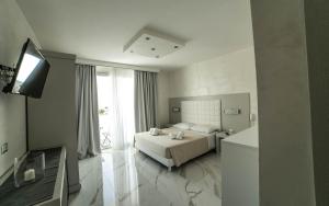 Habitación de hotel con cama y TV en Camera sul mare Riviera, en Porto Cesareo