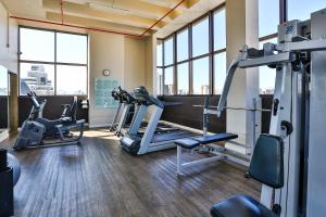 a gym with treadmills and ellipticals in a building with windows at Double Tree by Hilton São Paulo Itaim in Sao Paulo