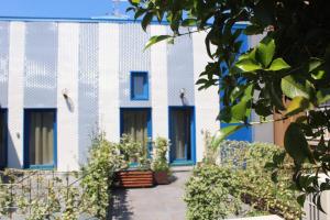 a blue and white building with plants in front of it at Time Out ApartHotel in Casalecchio di Reno