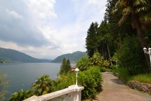 a path next to a body of water with mountains at Villa Rina Deluxe and Cottage in Porto Ceresio