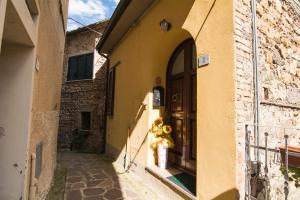 an alley with a building with a door and a fire hydrant at Tuscan retreat in Orciatico