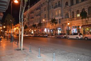 una calle de la ciudad por la noche con coches aparcados en HOTEL IMERETI TBILISi en Tiflis