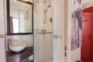 un baño con lavabo y ducha en Hotel Apolonia Paris Montmartre; Sure Hotel Collection by Best Western, en París 49 fotos más