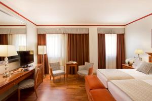 a hotel room with a bed and a desk at Starhotels Metropole in Rome