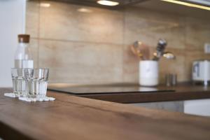 a counter with two glasses and a bottle on it at SODA19 Apartment - Budapest in Budapest