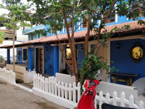 una casa azul con una valla blanca y una moto roja en The White Balcao, en Panaji