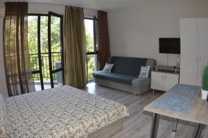 a living room with a bed and a couch at Apart Complex Amphora Palace in Golden Sands