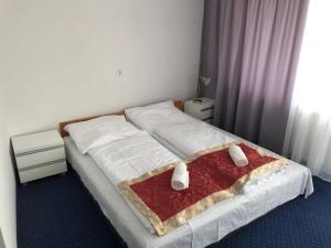 Złoty Łan في نوا سول: غرفة نوم بسرير أبيض مع بطانية حمراء
