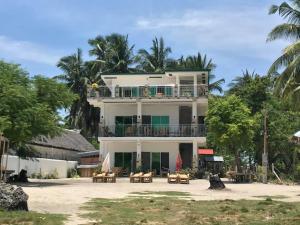 a large white building with tables and chairs at Homaja Roomrental in Panglao Island