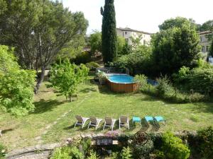 a yard with chairs and a swimming pool at Chambres d'hôtes Les Gragniotes in Tournissan