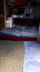 a bed in a room with a bed frame on the floor at Caravane au bord de la rivière in Saint-Corneille
