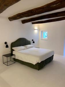 ナポリにあるLa Dimora di Chiaiaの白い部屋に大型ベッド1台が備わるベッドルーム1室が備わります。