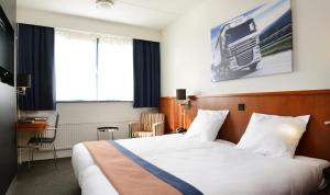 a hotel room with a bed and a television at Amrâth Hotel Eindhoven in Eindhoven