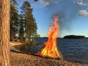 a large fire is coming out of the water at Koskenselkä Camping in Puumala