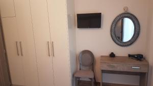 a bedroom with a desk and a mirror and a chair at Sunset in Plataria