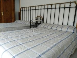 1 dormitorio con 2 camas y mesa en Casa en Ribeira Sacra, en Viñoás