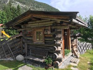 una cabaña de madera con un banco en el césped en Das Panoramablick, en Lofer