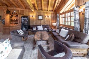 uma sala de estar com sofás e cadeiras numa cabina em Chalet les trois coeurs em Méribel
