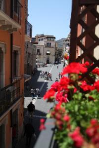 a view of a city street with red flowers at Bed & Breakfast Duomo Di Taormina in Taormina