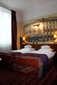 2 camas en una habitación de hotel con una foto en la pared en Branicki Boutique Rooms, en Białystok
