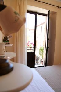 Habitación con cama y puerta a un balcón. en Bed & Breakfast Duomo Di Taormina, en Taormina