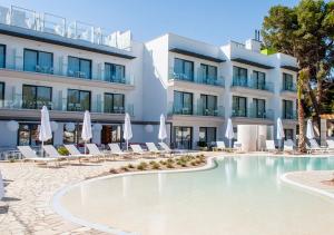 a hotel with a swimming pool in front of a building at Sol i Vida Hotel - Adults Only in Porto Cristo