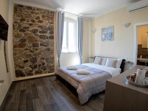 a bedroom with a bed and a stone wall at Vicolocorto Affittacamere in La Spezia