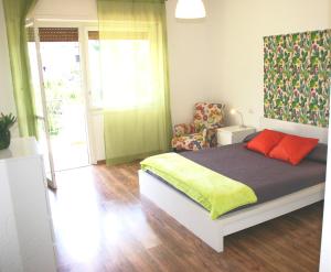 um quarto com uma cama com almofadas laranja e uma cadeira em CASA LUCIA em Meta