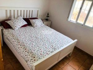 ein Schlafzimmer mit einem weißen Bett mit Blumen darauf in der Unterkunft Casa Rural Aguilas (Murcia), Venta San Felipe in Águilas + 13 Fotos