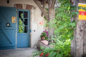 a blue door on a house with plants at Les Huguets in Villeneuve-sur-Lot