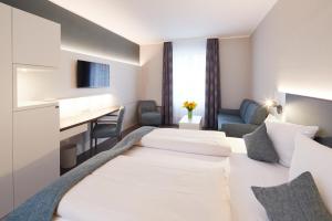 Ein Bett oder Betten in einem Zimmer der Unterkunft Stadthotel Freiburg Kolping Hotels & Resorts