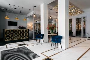 a lobby with blue chairs and a table at Hotel Apis in Kraków